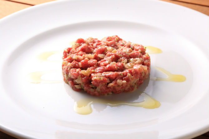 ディナーのみオーダー可能な牛肉のタルタルステーキは2,200円。生肉の甘みと旨みをひきだすため味付けはシンプル。保険所の認定を受けているからこそ提供できる一品だ